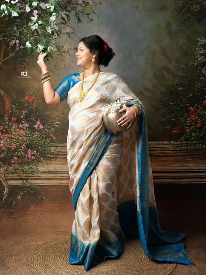 A whimsical portrait in a garden-like setting. The mom-to-be, dressed in a beautiful saree, interacts with the scenery, creating a storybook feel.