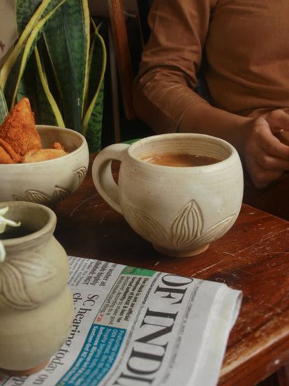 A cozy moment with a mug from the 'Gulbaan' collection, perfect for a warm chai on a slow evening. The piece evokes a sense of comfort and nostalgia.