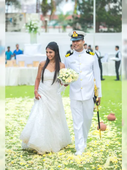 A candid shot of the bride and groom walking together after their ceremony, surrounded by a carpet of yellow and white flower petals.