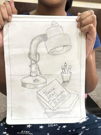 A still life sketch of a study desk, complete with a Harry Potter book. We love drawing things that are personal to us.