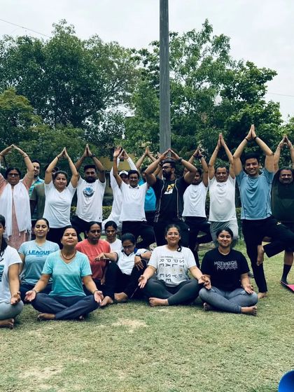 A group of participants in a combination of seated and standing poses, creating a beautiful tree-like formation. This represents growth and balance.