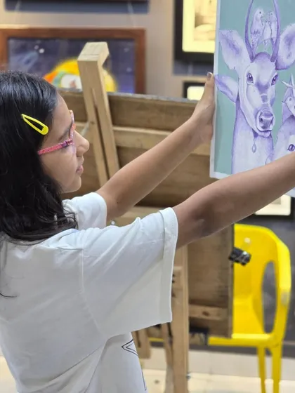 A student carefully examines her ballpoint pen artwork, checking her progress and planning her next steps. This is a key part of the creative process we teach.