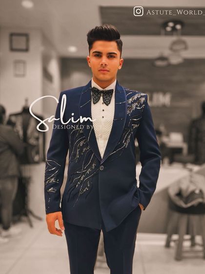A young client in a navy blue tuxedo with an asymmetric, abstract silver embroidery design. This shows my ability to create modern, artistic pieces for all ages.