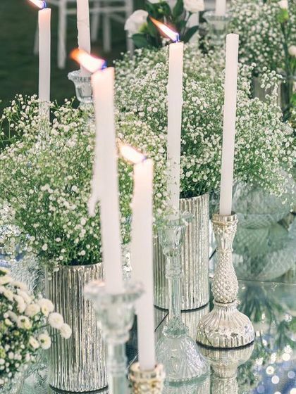 The soft glow of candles on a mirrored table, with the twinkling lights of the tent reflected below. This creates a beautiful, multi-layered visual experience.