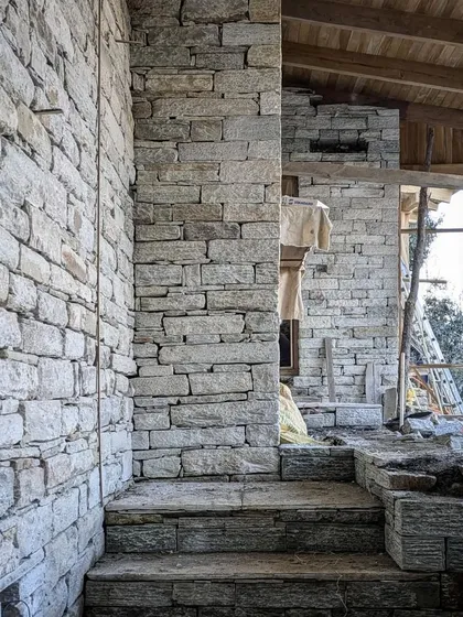 A view into one of the stone structures during construction. The different levels and steps are integrated directly into the stone-work, creating a seamless transition between spaces that feels carved from the earth.