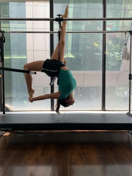 This is what progress looks like. A client mastering an advanced pose on the Cadillac, showcasing incredible flexibility and core strength. With guidance, you can get here too.