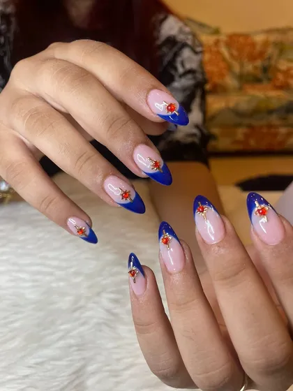 Into the blues right now with these royal blue French tips, accented with intricate red and gold gem clusters.