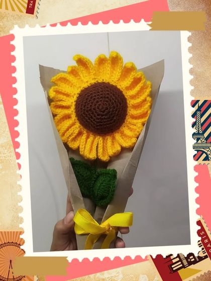 A single long-petal sunflower stem, wrapped and ready for gifting.