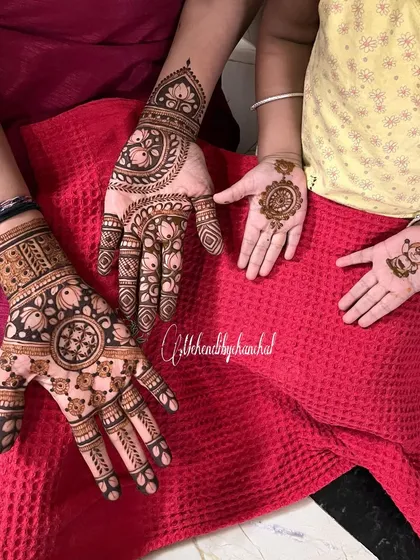 A lovely family photo with mehendi for both mom and her little one.