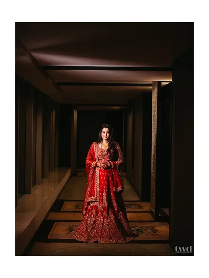 A stunning solo portrait of the bride Sanhita, looking like royalty in her red reception lehenga. The corridor provided a perfect leading line.