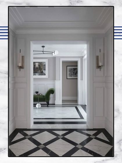 A beautiful transition from a hallway with black and white diamond-patterned marble flooring into a living space. The classic wall paneling and sconce lighting create a formal and inviting entryway.