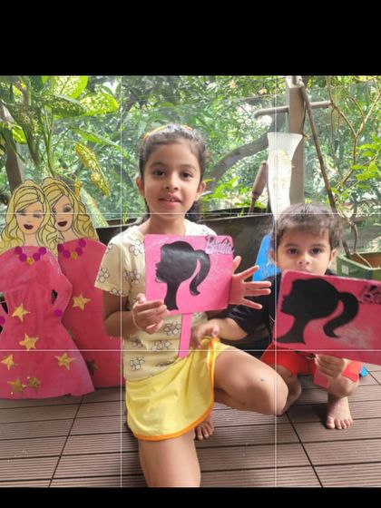Showing off their fabulous Barbie-themed artwork. After a session of pink paint and glitter, these kids were so proud to display their creations.