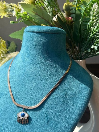 A trendy evil eye pendant on a gold-plated snake chain, a popular accessory choice.