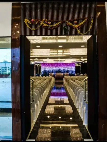The main entrance to Ellora Banquet hall, offering a glimpse of the grand seating arrangement inside. The dark wood and glass doors give it a modern and sophisticated look.