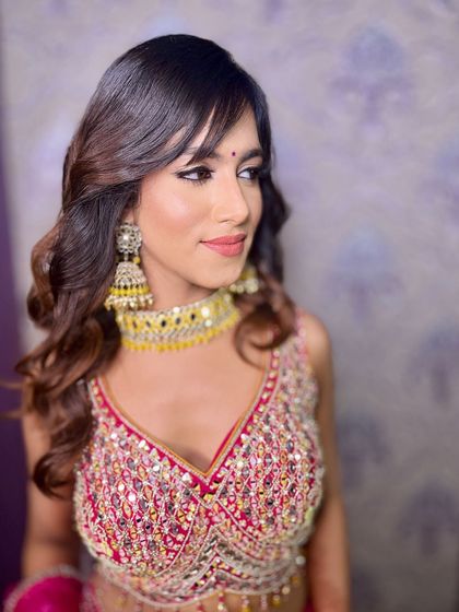 A beautiful side profile, highlighting the soft waves in her hair and the flawless finish of her makeup.