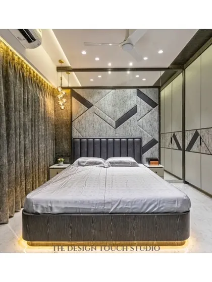 This bedroom features a bold, geometric headboard that extends onto the wardrobe panels, creating a dynamic and cohesive design. The under-bed lighting adds a modern, floating effect.