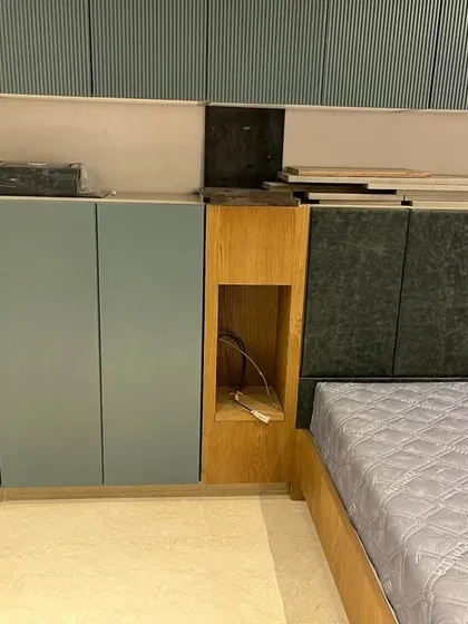 A work-in-progress shot of a bedroom project, showing the built-in cabinets and headboard before the final finishing touches. This reveals the underlying structure and precision required for integrated furniture.