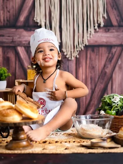 A little baker whipping up some love. This creative 'Masterchef' themed shoot with bread, flour, and an apron is a recipe for adorable photos.
