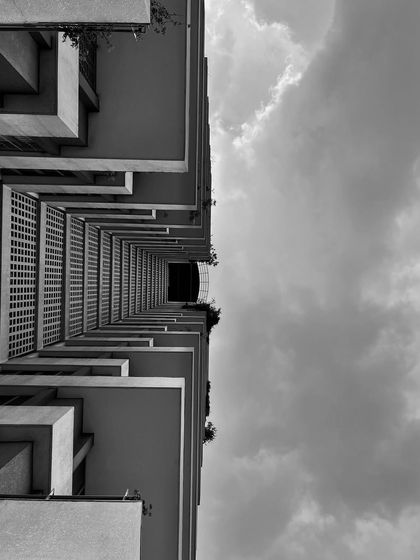 An abstract, upward view of a building's geometric balconies. I appreciate the art in architecture and find properties that are visually compelling from every angle.