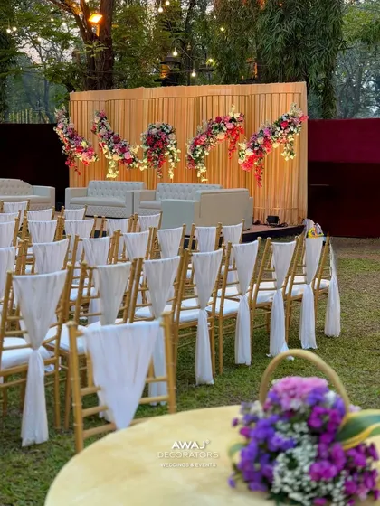 A view of the guest seating from a table in the foreground, showing the elegant chair drapes and a purple floral centerpiece.