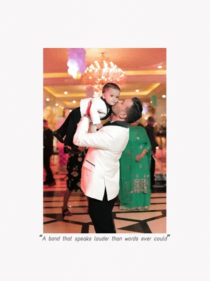 A father's love captured in a single, candid moment. He lifts his son high in the air during the birthday celebration, a memory of pure joy.