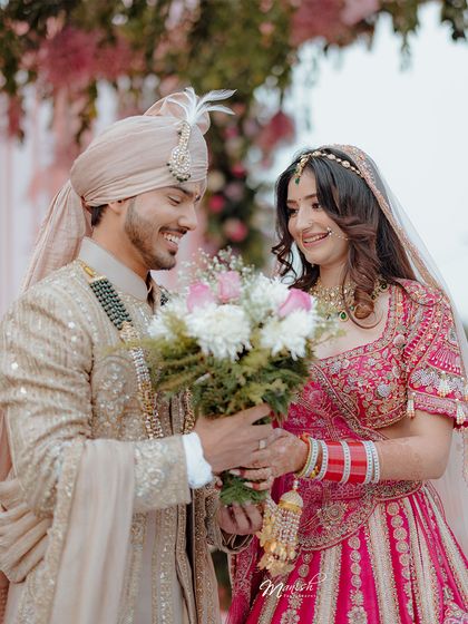 The groom presents his bride with a bouquet, a modern romantic gesture amidst the traditional wedding ceremony.