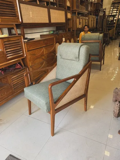 Front view of the sage green lounge chair with teak frame.