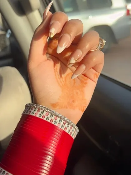 Summer love. A beautiful shot of our abstract white and gold nails, perfectly complementing the traditional red bridal bangles.