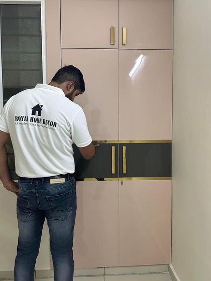 Another custom wardrobe design, this one in a two-tone pink and black finish with elegant gold handles.