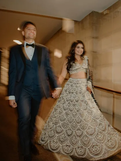 A candid, motion-blur shot of the couple walking hand-in-hand. This artistic photo captures the energy and excitement of their wedding day as they move from one moment to the next.