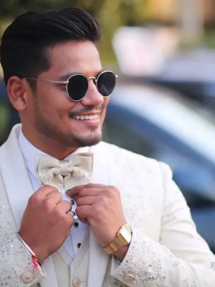Seeing our clients shine is my greatest reward. Here, our groom looks dashing in a custom-tailored ivory tuxedo, perfect for his reception, embodying pure joy and elegance.