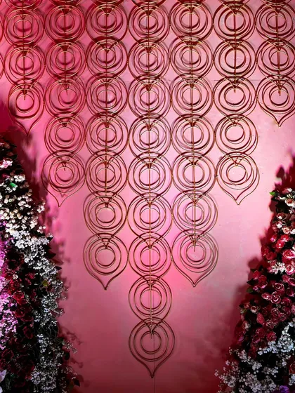 A cascading wall installation made of interlocking golden rings, another artistic representation of eternal connection within our 'Anant' theme.