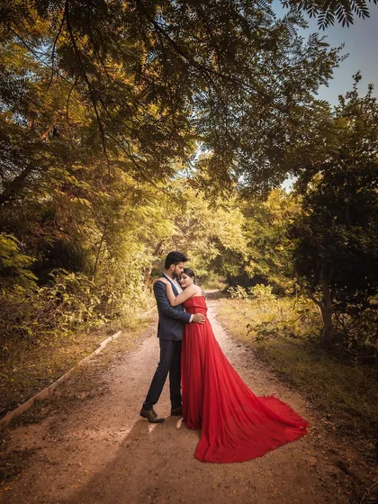 For this pre-wedding portrait, I wanted to create a sense of fairytale romance. The flowing red gown stands out against the lush, sun-dappled forest path, creating a wide, cinematic frame that feels like a scene from a movie.