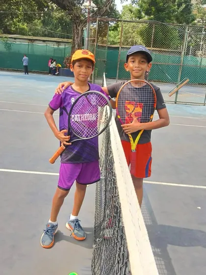 Two young boys, friends and competitors, share a moment at the net during the MSSA tournament.