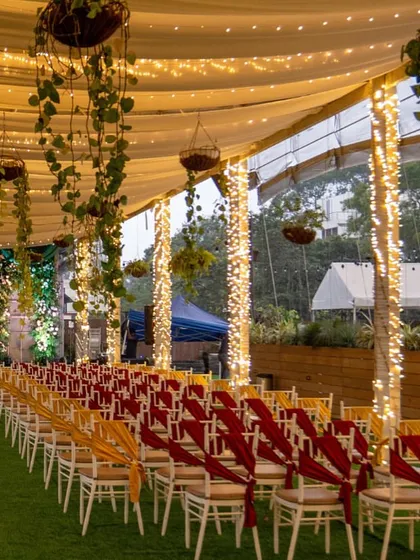The aisle of our Sky Terrace is ready for a grand entrance, lined with chairs and illuminated by fairy lights, leading to a beautifully decorated stage.