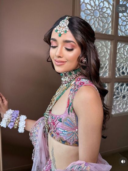 A soft and romantic half-updo with curls, adorned with tiny flowers. This look was created for a masterclass demonstration in Pune.