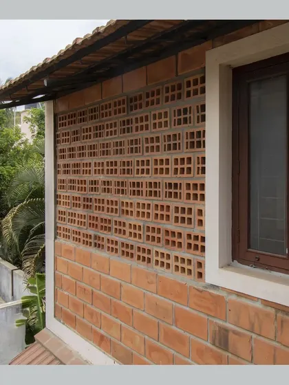 A close-up of a jaali wall made from hollow clay blocks, providing ventilation and a decorative screen.