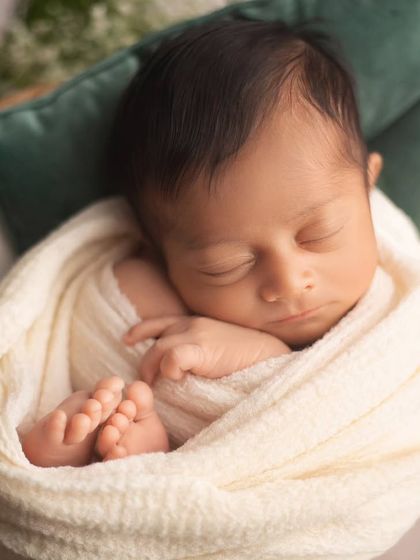 A close up on this peacefully sleeping baby, with his tiny feet peeking out. The simple cream wrap is beautifully accented by the fresh white flowers and greenery.