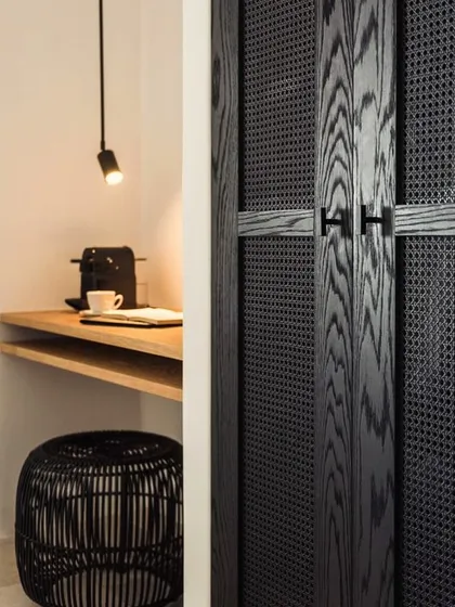 We love the texture play in this custom wardrobe, which pairs charcoal-finished ash wood with black wicker panels. The clean lines and contrasting white ash counter create a modern yet warm look for bedroom storage.