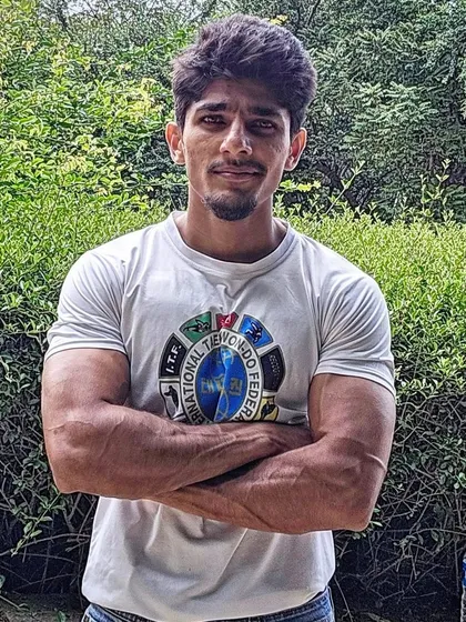 A portrait of me in an ITF Taekwondo t-shirt, showing the arm and shoulder strength developed through consistent training.