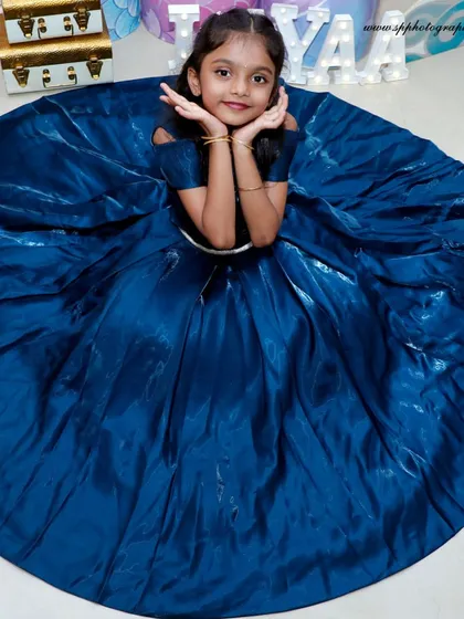 For a child's birthday portrait, we focus on making them feel like the star of the day. This shot, with the full spread of the beautiful blue gown, captures the magic and confidence of a birthday girl.