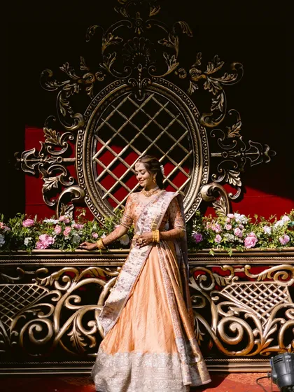 A majestic shot of the bride against an ornate backdrop. The grandeur of the setting is matched by the elegance of her traditional attire and flawless makeup.