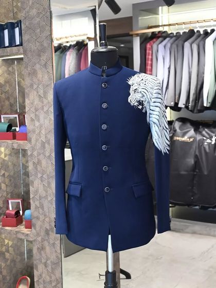 A navy blue Jodhpuri jacket with a powerful white tiger motif painted on the shoulder and sleeve. This is a bold, artistic piece for a client who wants to stand out.