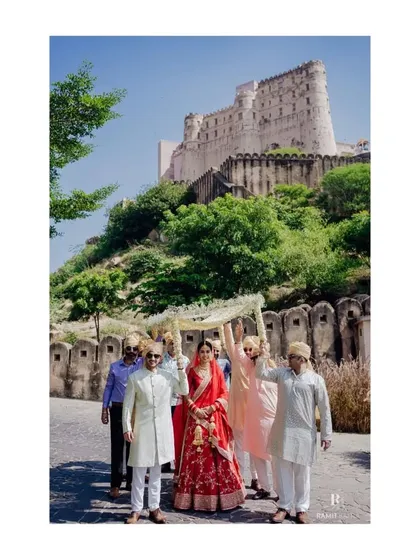 The bride's grand entrance under a phoolon ki chaadar, with the magnificent Alila Fort in the background. I coordinate every element to ensure these key moments are picture-perfect.