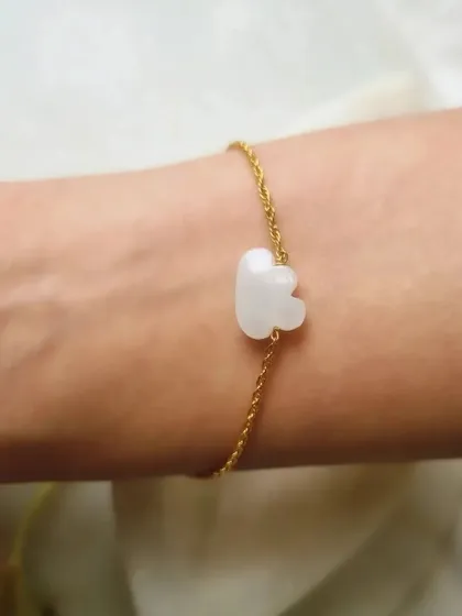 A moonstone cloud bracelet, worn on the wrist. This charm is designed to bring peace and calm, while also attracting abundance and good fortune in love.