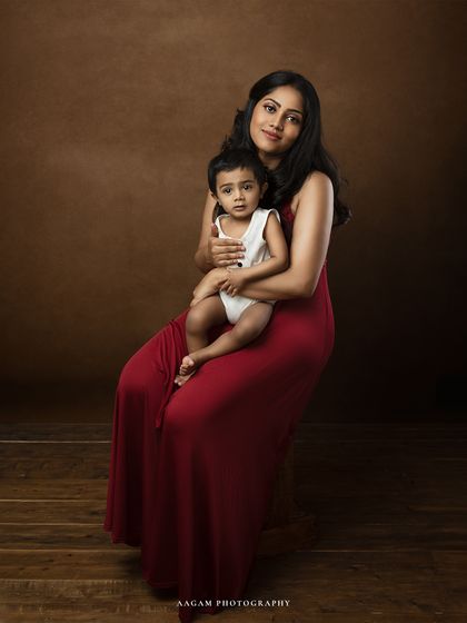 A timeless frame where love lives forever. This is a fine art portrait of a mother and her older baby, posed elegantly against a classic studio backdrop.
