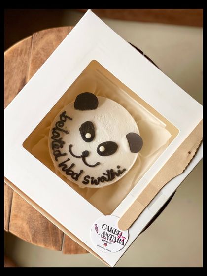 An adorable panda-themed bento cake for a belated birthday celebration. The simple, cute panda face is sure to make anyone smile.