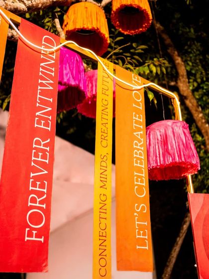 Custom-printed banners with messages like "Forever Entwined" and "Let's Celebrate Love" hang as part of the decor, reinforcing the theme of the celebration.
