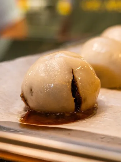 Freshly made dumplings for an Onam feast, with the filling peeking through. The image highlights the handmade quality of the food.