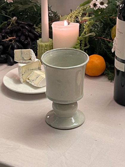 The 'Heccu' goblet, with its regal chalice design, sits on a candlelit table. Each piece bears the hallmark of fine traditions and meticulous craftsmanship.